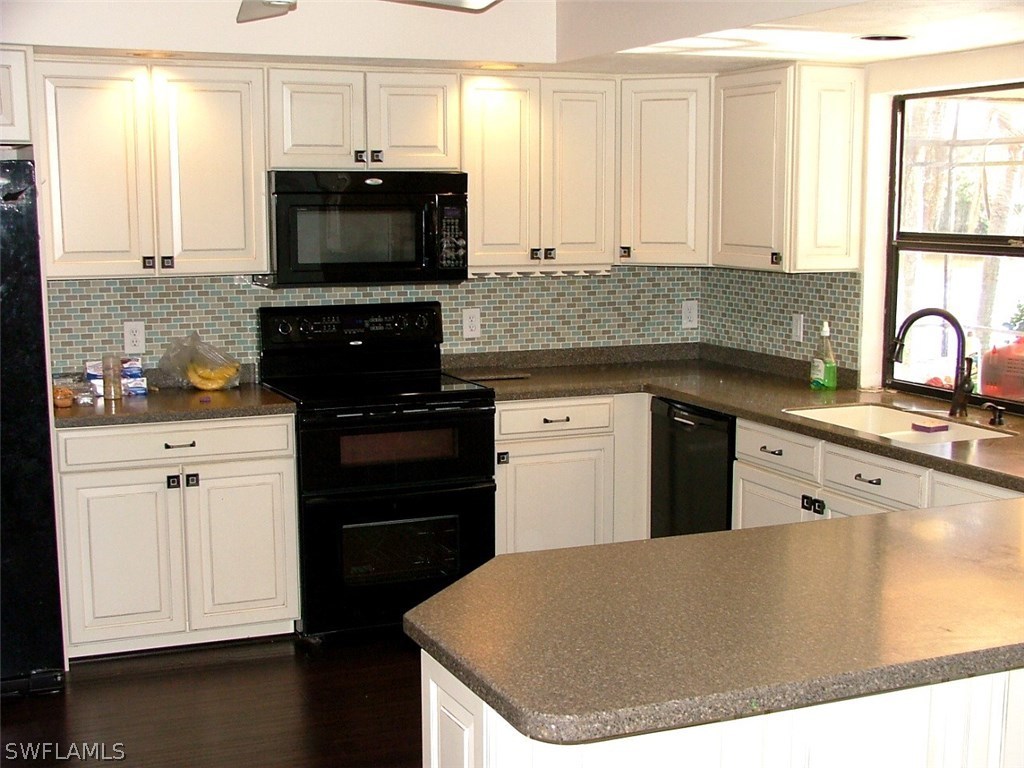 17240 Trellis Road Fort Myers, FL 33967 - Photo 8 of 12 a kitchen with stainless steel appliances granite countertop a stove a sink and a microwave