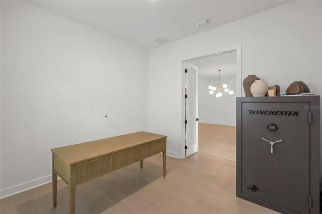 a bedroom with a bed a mirror and a chandelier