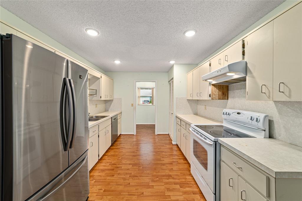 8678 Southwest 95 Street, Unit D Ocala, FL 34481 - Photo 14 of 36 a kitchen with stainless steel appliances a sink and a refrigerator