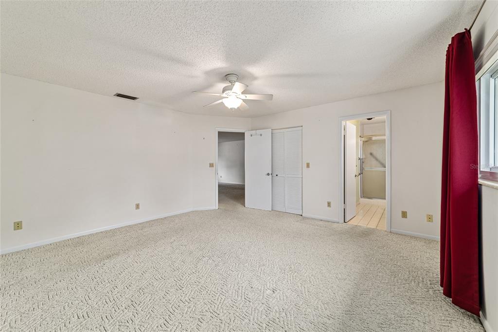 8678 Southwest 95 Street, Unit D Ocala, FL 34481 - Photo 19 of 36 a view of an empty room with a ceiling fan