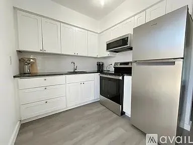a kitchen with stainless steel appliances a refrigerator sink and white cabinets