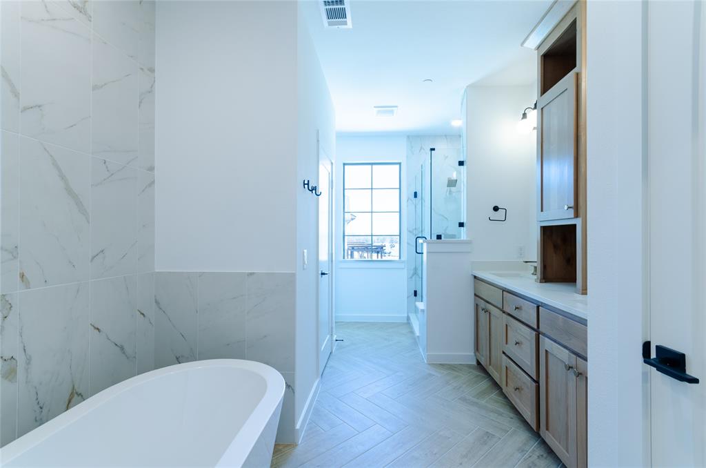 1248 Armstrong The Colony, TX 75056 - Photo 12 of 25 a bathroom with a bathtub a toilet a sink and mirrors