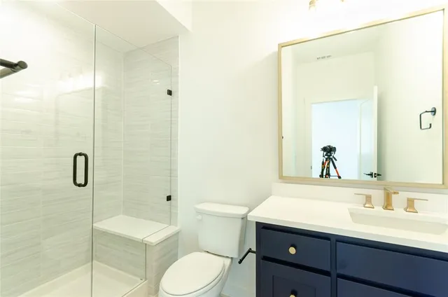 a bathroom with a sink toilet a mirror and shower