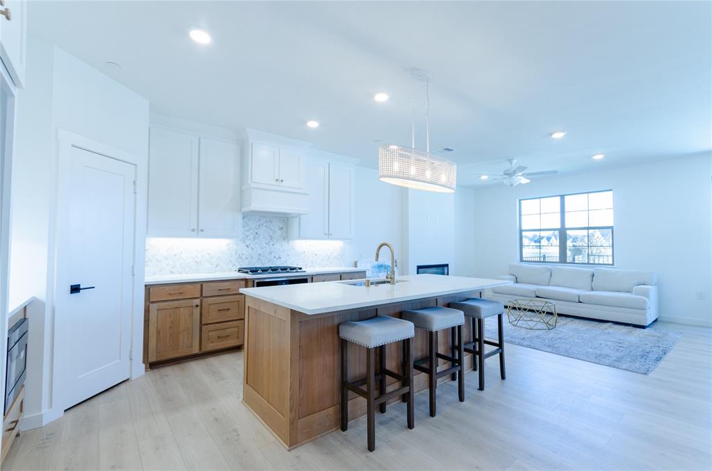 1248 Armstrong The Colony, TX 75056 - Photo 3 of 25 a kitchen with stainless steel appliances granite countertop a stove a sink a refrigerator and white cabinets with wooden floor