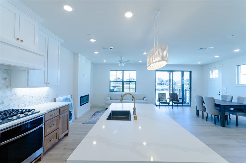 1248 Armstrong The Colony, TX 75056 - Photo 4 of 25 a large kitchen with stainless steel appliances a stove a sink a dining table and chairs