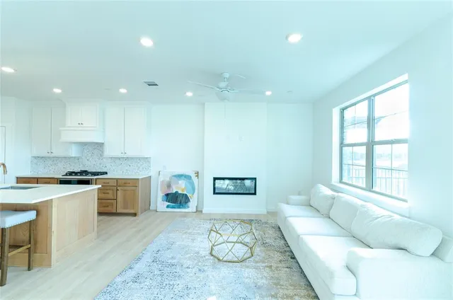 a kitchen with a dining table chairs sink and white cabinets