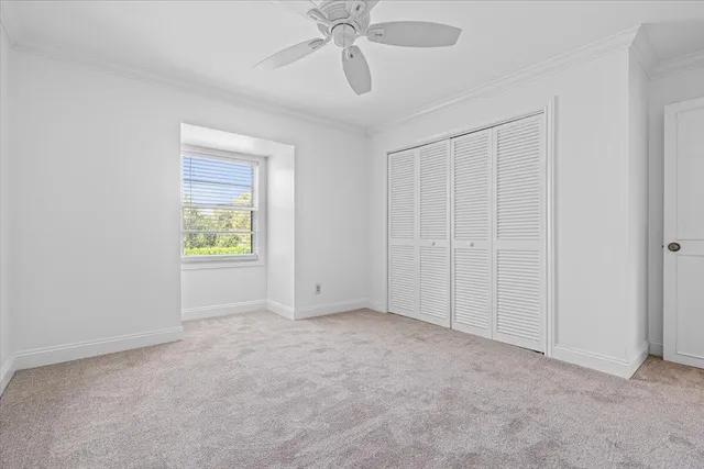 an empty room with fan and windows