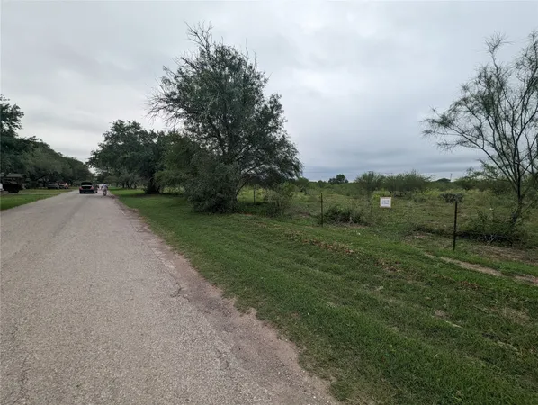 a view of a field with trees in background