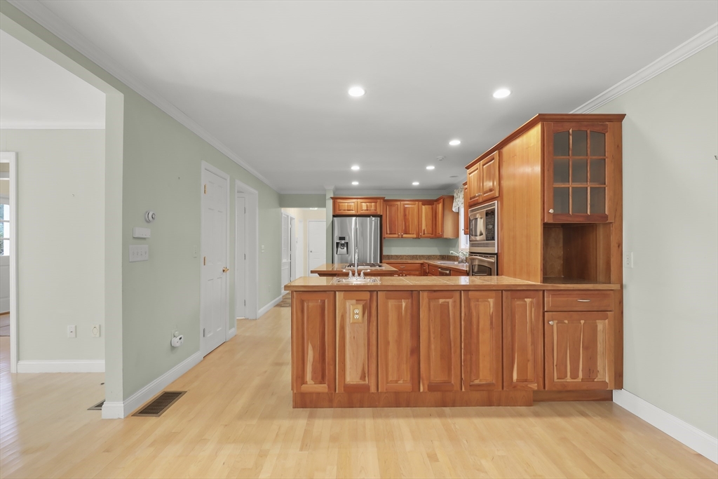 2 Tricia Road Falmouth, MA 02556 - Photo 4 of 39 a large white kitchen with stainless steel appliances granite countertop a stove a sink and a refrigerator with wooden floor