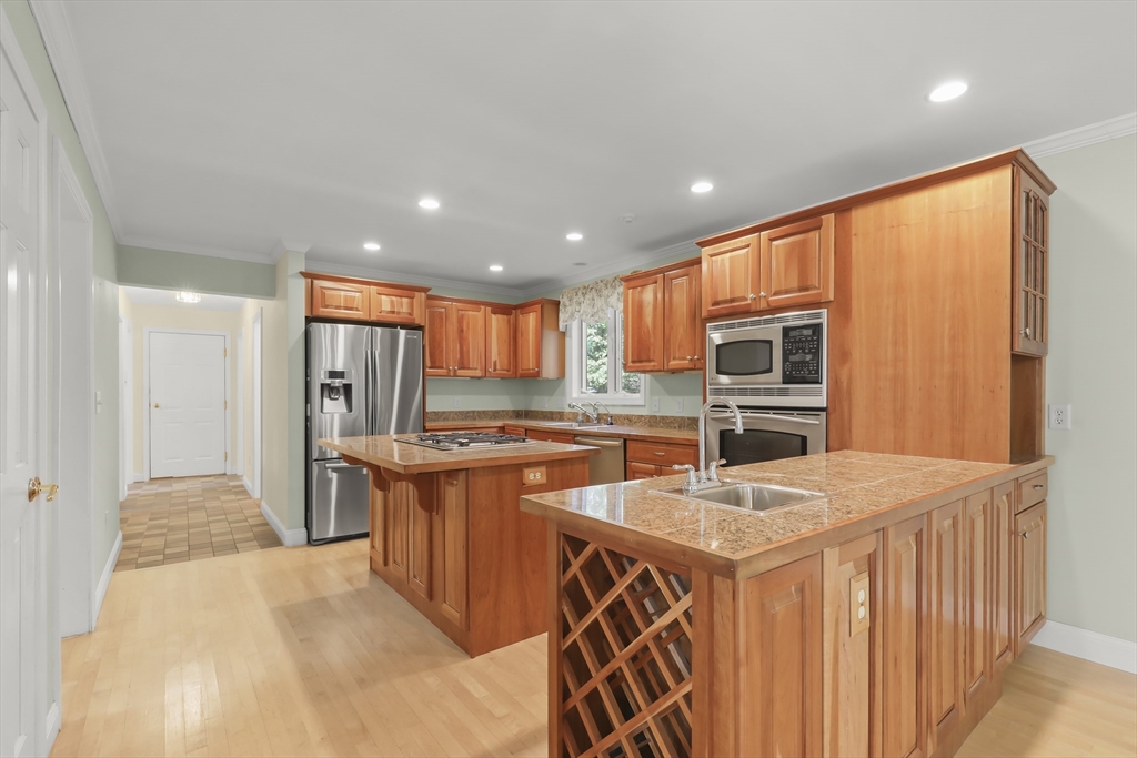 2 Tricia Road Falmouth, MA 02556 - Photo 5 of 39 a kitchen with stainless steel appliances granite countertop a refrigerator a sink dishwasher and a stove with wooden cabinets