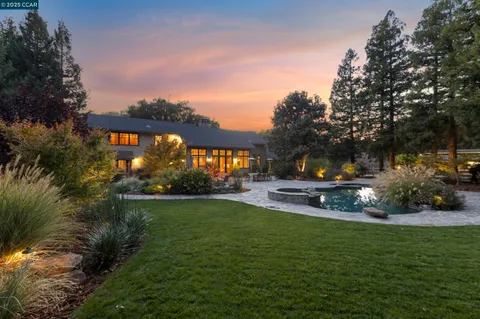 a view of a park that has a sign board large trees