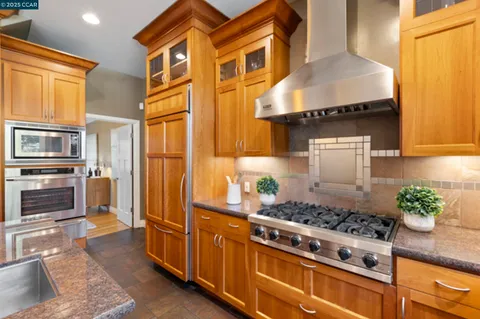 a kitchen with stainless steel appliances kitchen island granite countertop a sink and cabinets