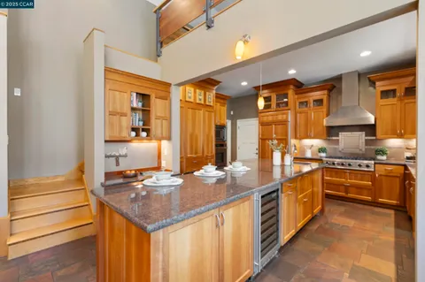 a large kitchen with stainless steel appliances granite countertop a stove a sink and a microwave