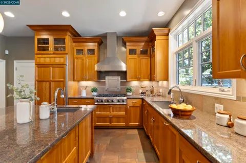 a kitchen with stainless steel appliances granite countertop sink stove and wooden cabinets