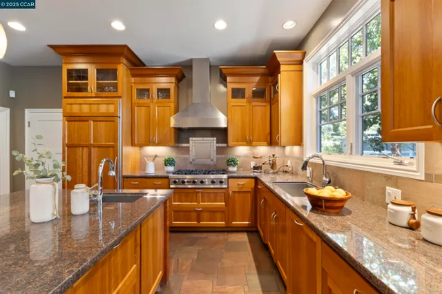 a kitchen with stainless steel appliances granite countertop sink stove and wooden cabinets