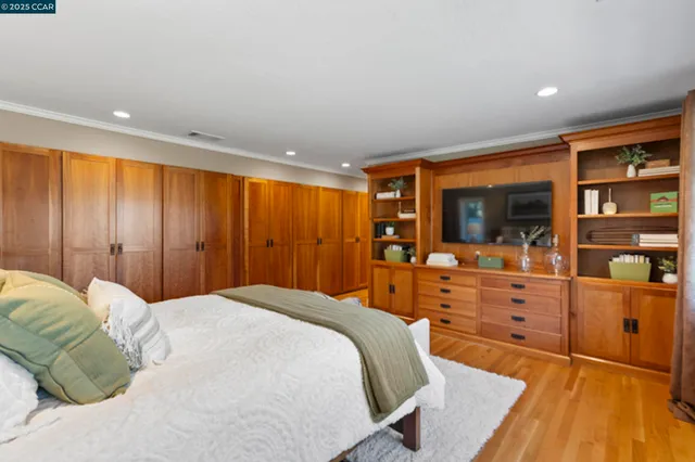 a spacious bedroom with a bed and wooden floor