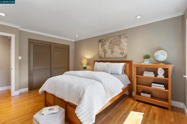 a bedroom with a bed and wooden floor