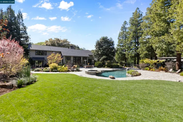 a view of a house with backyard and sitting area