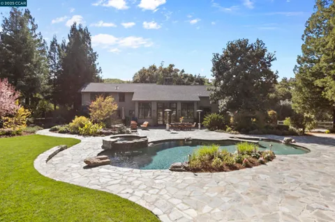 a view of backyard with outdoor seating and trees