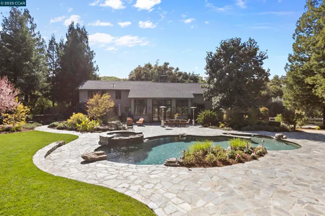 a view of backyard with outdoor seating and trees