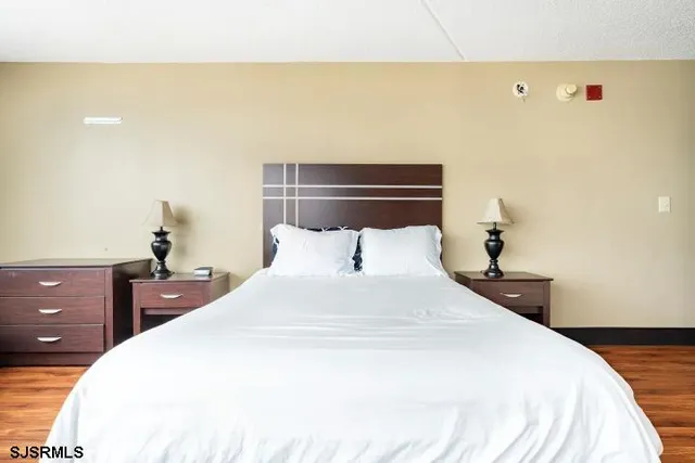 a bedroom with a bed and a lamp on dresser