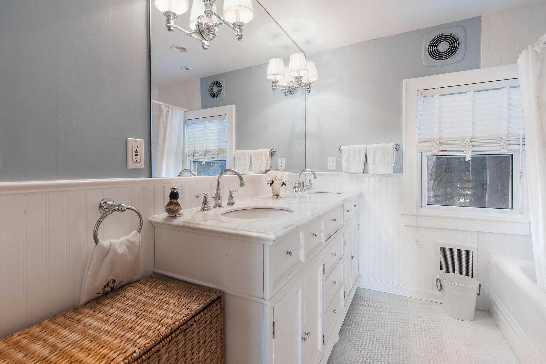67 Relihan Road Darien, CT 06820 - Photo 15 of 25 a en suite bathroom with a double vanity sink a mirror and a bathtub