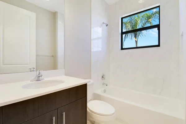 a large white kitchen with a sink and cabinets