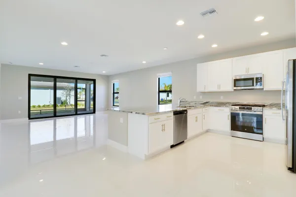 a view of a kitchen with a sink and a refrigerator