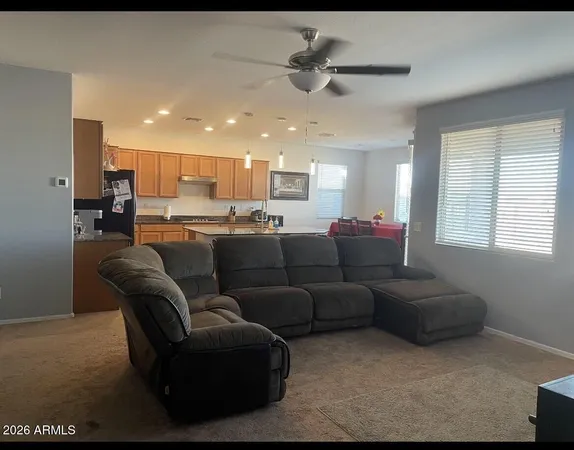 a living room with furniture and a ceiling fan