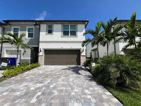 a front view of a house with a yard and a garage