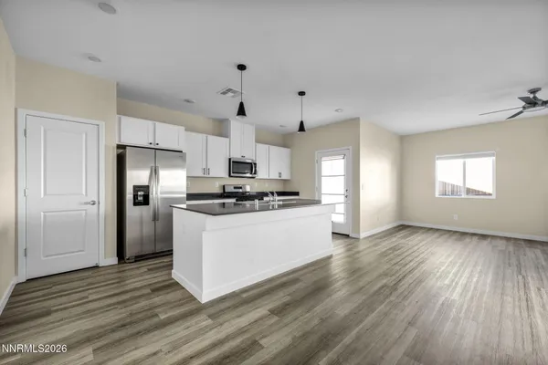 a kitchen with granite countertop a refrigerator and a stove top oven