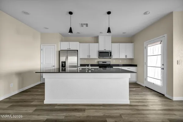a kitchen with stainless steel appliances granite countertop a stove a sink and white cabinets