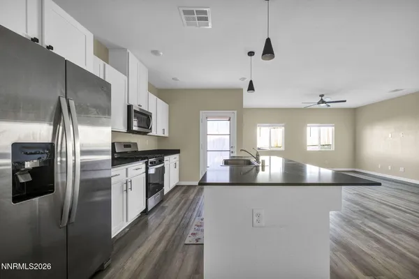 a kitchen with stainless steel appliances granite countertop a refrigerator a stove a sink and a refrigerator