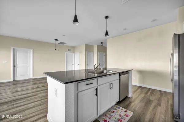 a kitchen with granite countertop a sink and refrigerator