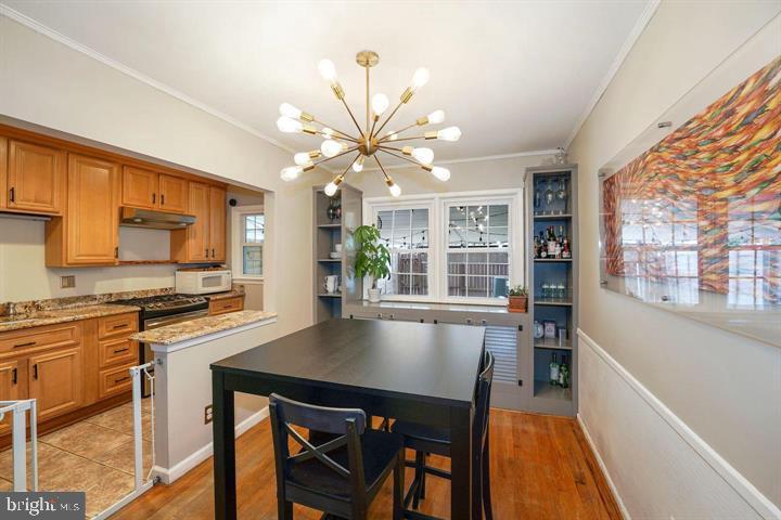 3528 Beech Avenue Baltimore, MD 21211 - Photo 5 of 19 a kitchen with stainless steel appliances a stove a sink dishwasher and a refrigerator with wooden floor