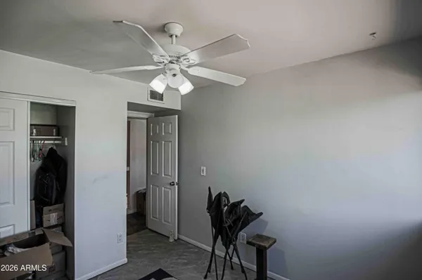 a view of a hallway with closet and a chandelier fan