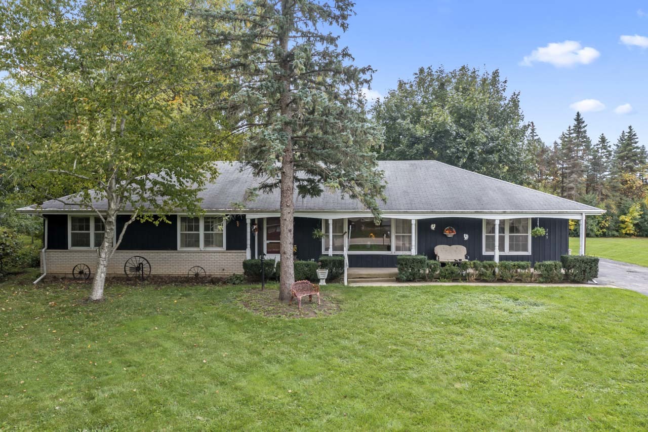 a front view of a house with a garden and trees