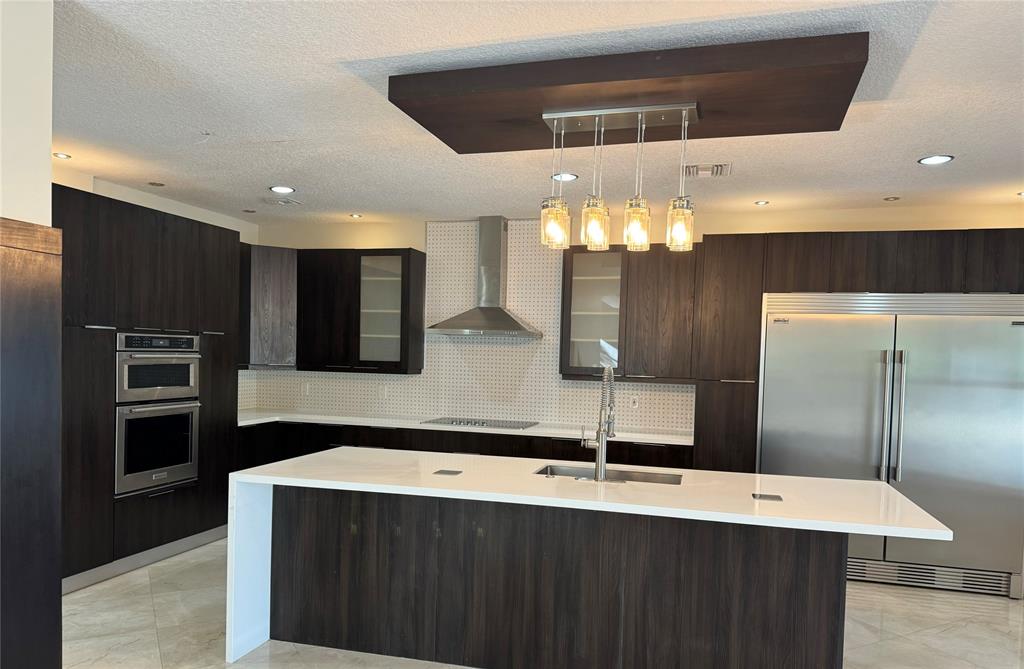 a large kitchen with a large counter space cabinets and stainless steel appliances