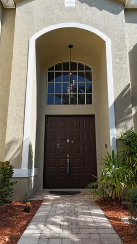 a view of a house with a yard and potted plants