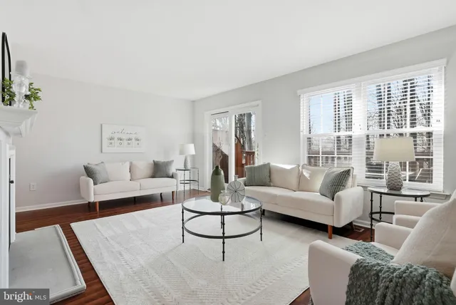 a living room with furniture a fireplace and wooden floor