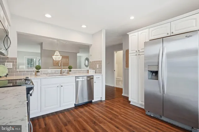 a living room with furniture large window and wooden floor