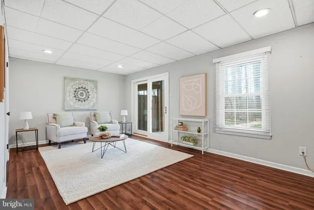 a view of a hallway with a livingroom and a bathroom with sink