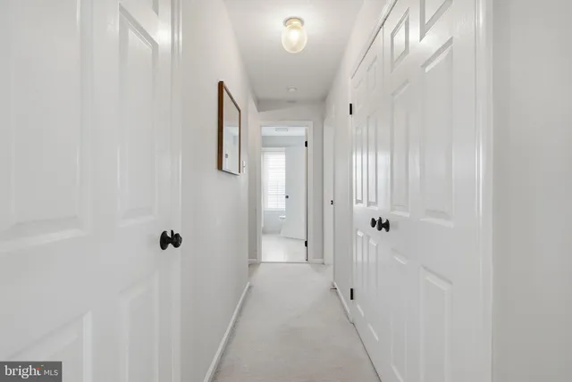 a spacious bedroom with a bed a mirror and windows