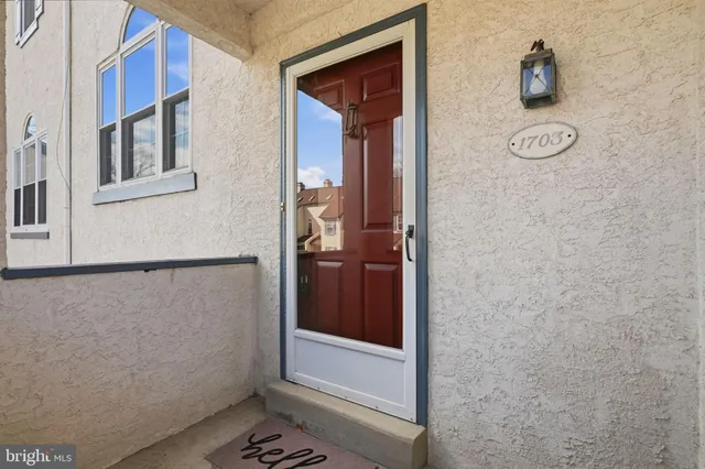 a view of staircase with lots of frames on wall and a window