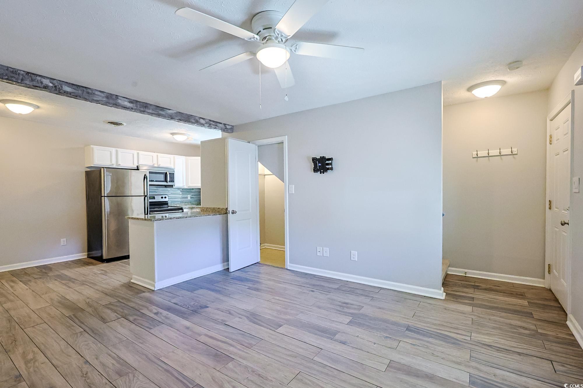 718 Juniper Drive Surfside Beach, SC 29575 - Photo 5 of 18 Kitchen with stainless steel appliances, white cabinetry, a peninsula, light stone countertops, and backsplash