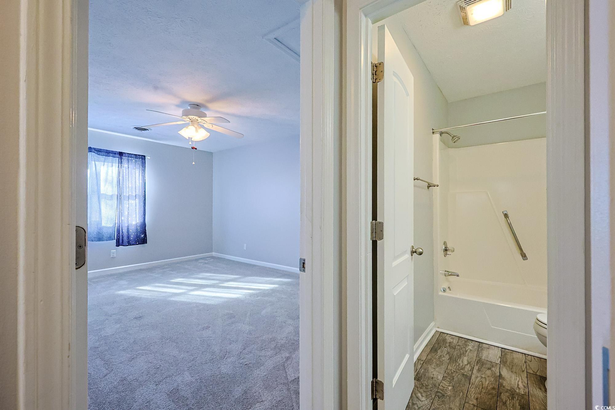 718 Juniper Drive Surfside Beach, SC 29575 - Photo 9 of 18 Full bath featuring bathtub / shower combination, carpet floors, a textured ceiling, and a ceiling fan