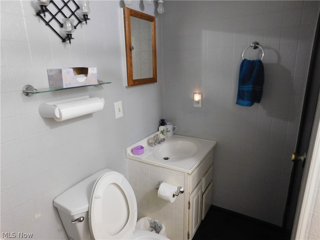 4728 Zenobia Road Wakeman, OH 44889 - Photo 15 of 25 Bathroom featuring toilet, vanity, and tile walls