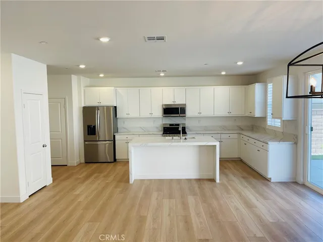 a kitchen with a sink white cabinets and stainless steel appliances