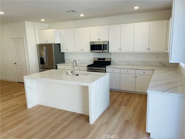 a kitchen with granite countertop white cabinets and black appliances