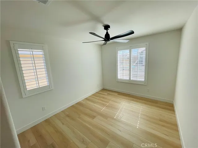 a view of a room with a hardwood and a ceiling fan